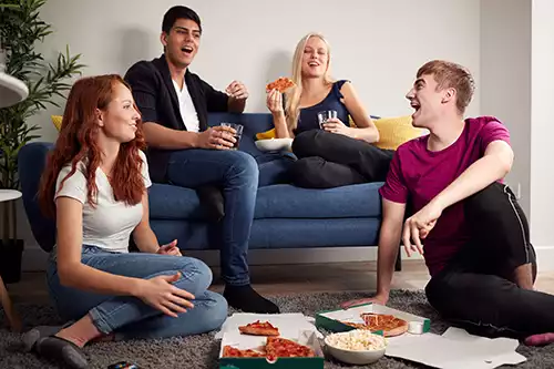 students enjoying pizza in student housing financed by RMC Funding